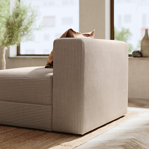 Moderno módulo de sofá beige con textura acanalada, grandes cojines y reposabrazos para mayor comodidad.