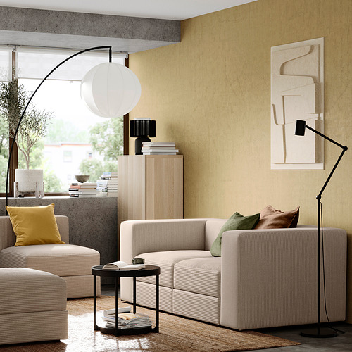 Una acogedora sala de estar con un sofá JÄTTEBO beige, decoración moderna y luz natural.