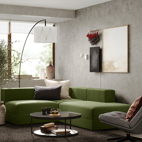 Sala de estar moderna con sofá JÄTTEBO verde, elegantes mesas de café, decoración moderna y una gran ventana.