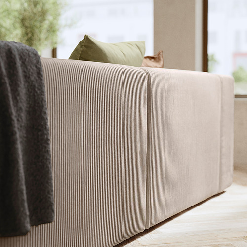 Moderno sofá beige con almohada verde, acogedor y elegante.