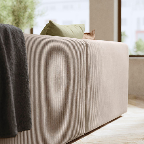 Moderno sofá acolchado blanco con almohada verde, manta gris, suelo de madera, vista a la ventana y gato.
