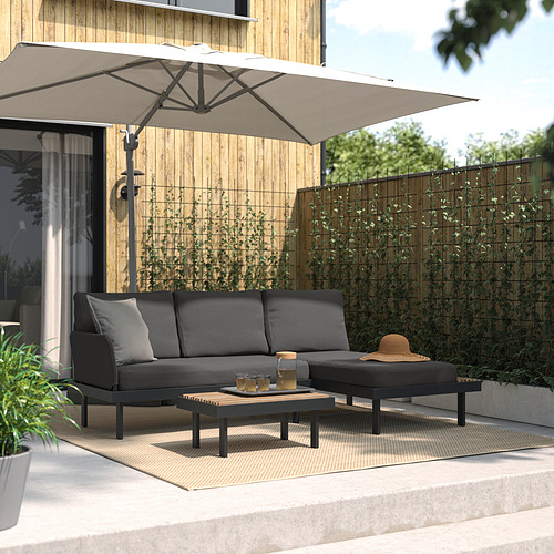 Patio trasero moderno con seccional exterior negro, mesa de café y sombrilla grande para dar sombra.