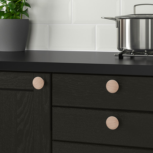 Mueble negro con pomos y planta de madera.