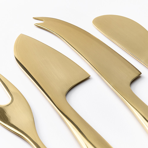 Seis cuchillos y tenedores de metal dorado pulidos y colocados cuidadosamente sobre una superficie blanca.