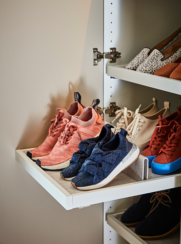 Estante de armario blanco con zapatillas rosas, azules y beige cuidadosamente organizadas.
