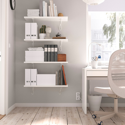 Estantería de pared blanca BERGSHULT con libros, cajas y decoración. Montado con dos soportes, encaja perfectamente en la esquina de la habitación sobre un escritorio.
