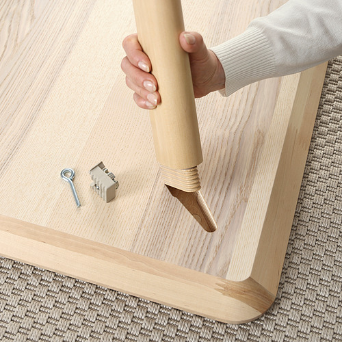 La persona ensambla la mesa de madera con las herramientas proporcionadas. Construcción robusta con acabado de madera natural.