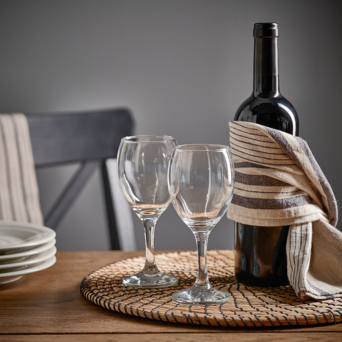 Mesa con copas y botella de vino ÄNKEBLOMSTER, lista para los invitados.