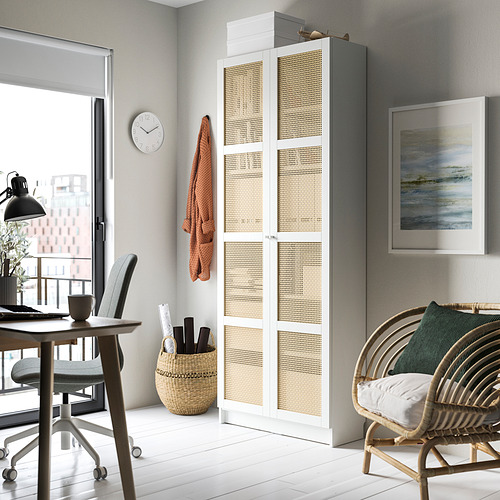 Moderna oficina en casa con librería BILLY blanca y bambú, escritorio gris, silla, reloj, cuadro y silla de mimbre con cojín.