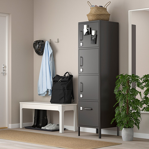 Una taquilla IDÅSEN en color gris, fabricada en acero, con múltiples compartimentos. Se mantiene alto con un diseño elegante junto a un banco blanco y una planta en maceta.