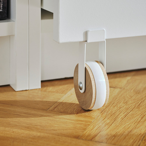 Librería BILLY blanca con suelo de madera, con cajón circular con ruedas.