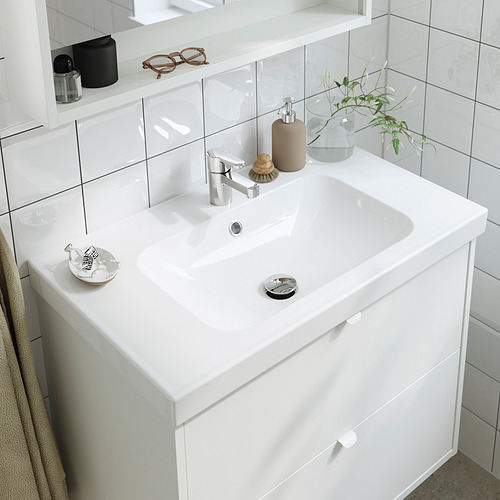 Lavabo de baño moderno con grifo cromado, dispensador de jabón, toalla, planta y aireador ahorrador de agua.