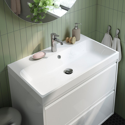 Un lavabo de baño moderno con lavabo de mármol integrado, elegante grifo cromado y almacenamiento para jabón. Encaja perfectamente en un lavabo.