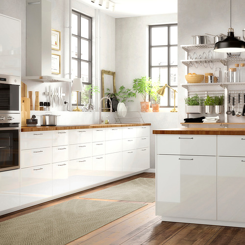 Cocina blanca moderna con encimeras de madera, ventanas grandes, electrodomésticos elegantes y alfombras.