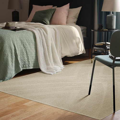 Dormitorio sereno con alfombra, silla, cama y decoración beige FULLMAKT. Alfombra más grande que la silla, se adapta bien a la habitación.