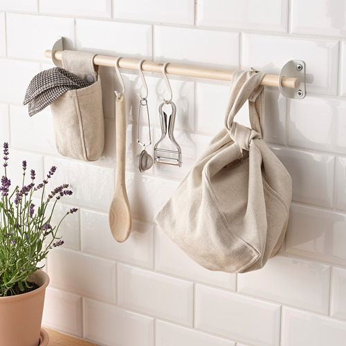 Organizador de pared de cocina con ganchos y bolsas de tela para colgar, utensilios de almacenamiento y toalla.