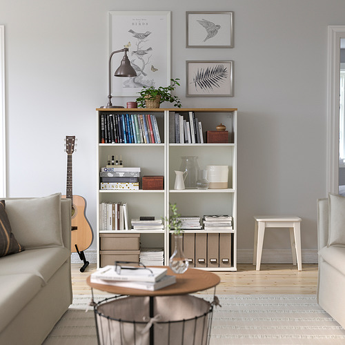 Acogedora sala de estar con librería SKRUVBY. Madera clara, diseño moderno, lleno de libros, rodeado de muebles cómodos.