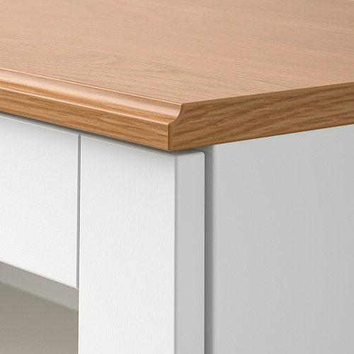 Detalle del borde de la mesa SKRUVBY: tablero de madera lisa y pulida con base blanca y limpia.