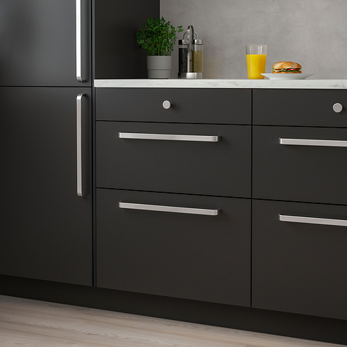Cocina moderna con manijas KALERUM negras, encimera de mármol, planta, comida, jugo de naranja.