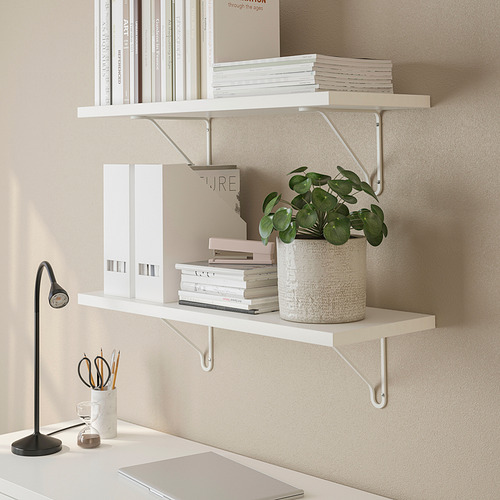 Los estantes minimalistas sostienen libros, plantas y lámparas, enfatizando el espacio vertical eficiente.