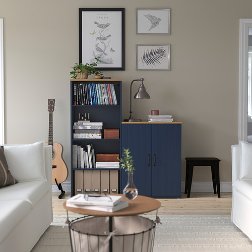 Acogedora sala de estar con muebles SKRUVBY azules, guitarra, arte, sofá blanco y mesa de café.