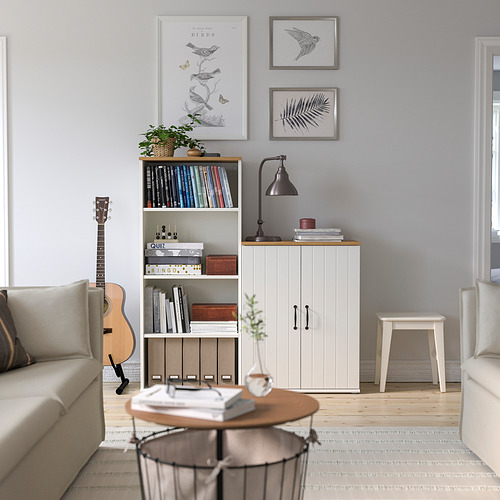 Salón moderno con muebles ligeros. Sofá beige, mesa de centro con jarrón, guitarra junto a estantería, estampados en la pared, taburete junto a la ventana.
