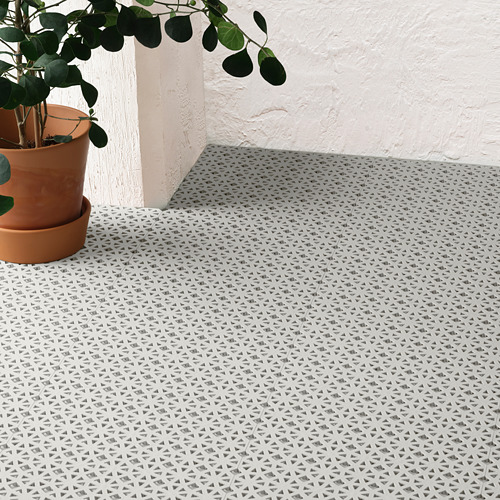 Un suelo de exterior de baldosas con motivos triangulares, ideal para balcones. Una planta en maceta se encuentra a la izquierda, destacando su diseño resistente a la intemperie.