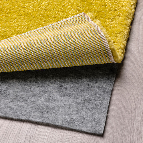 Alfombra brillante con motivo de rayas y base de moqueta gris, con funcionalidad antideslizante.