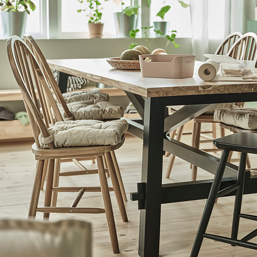 Silla SKOGSTA en color beige, madera maciza de acacia con respaldo arqueado y asiento acolchado.