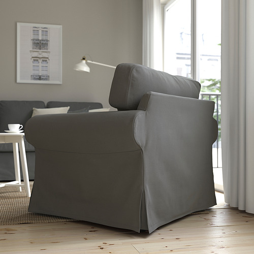 Sala de estar moderna con un gran sillón EKTORP gris, cojines de felpa, cerca de la ventana, que ofrece comodidad y apoyo.