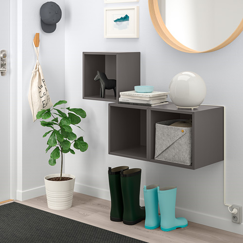 Mueble de pared EKET negro con armarios abiertos y cerrados, artículos de decoración y accesorios.