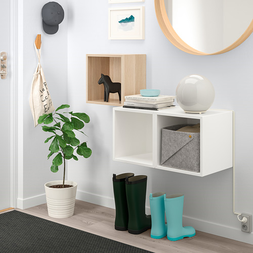 Armarios EKET de pared con espejo, plantas y botas.