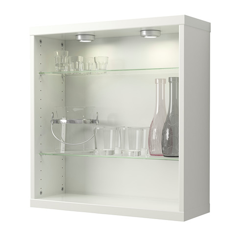 Mueble de pared blanco con estantes de vidrio, iluminado por focos, que exhibe cristalería y jarrones transparentes.