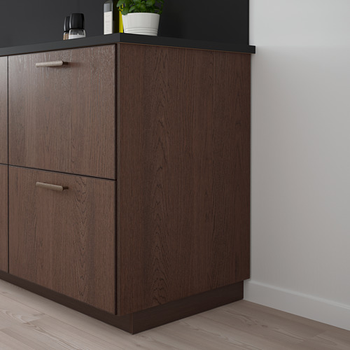 Mueble SINARP de madera oscura, alto y delgado, con asas elegantes. Encaja a la perfección en el rincón de la cocina.