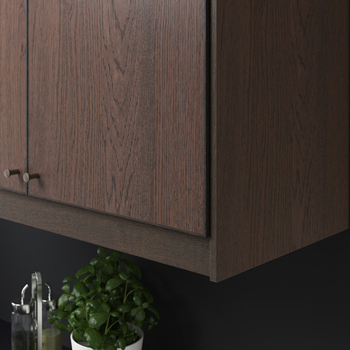 Gabinete de madera oscura con manijas de metal; planta debajo.