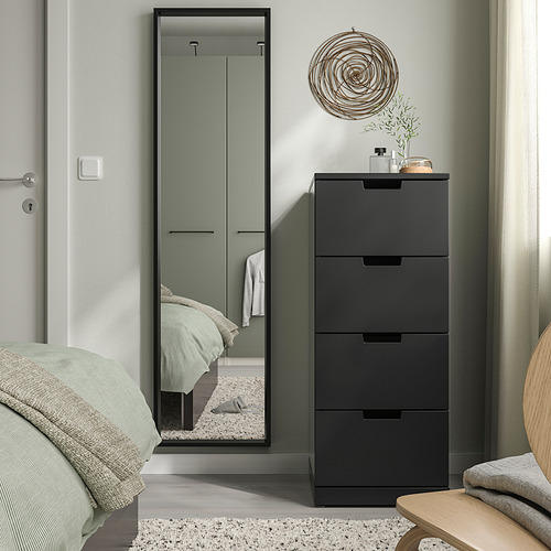 Dormitorio moderno con tocador negro NISSEDAL, espejo alto, ropa de cama de salvia, silla de madera, decoración de pared en espiral.