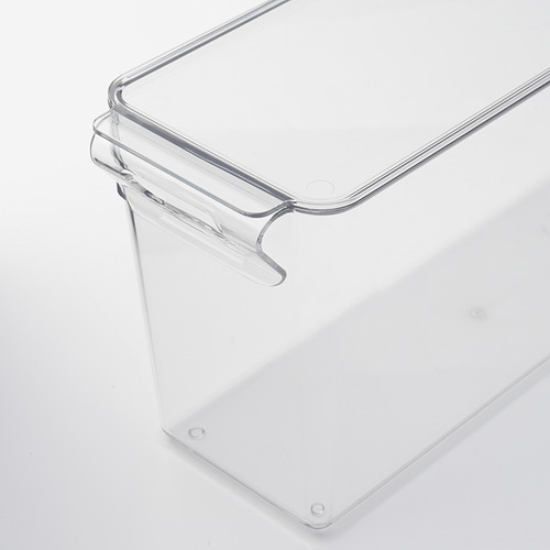 Caja de almacenamiento de plástico transparente con asa y tapa, diseñada para uso en refrigerador. Robusto y transparente para facilitar la visualización.