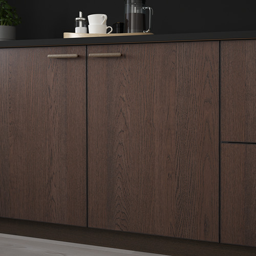 Gabinetes de cocina de madera oscura con manijas elegantes, con una encimera con artículos de café, que muestran almacenamiento y organización.
