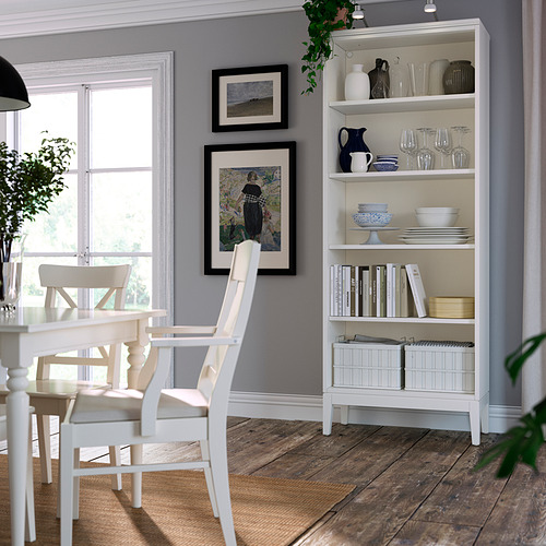 Librería blanca, pared gris, arte enmarcado, silla de comedor, ventana, platos, jarrones.