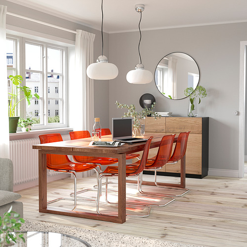 Bright dining room with a modern MÖRBYLÅNGA wooden table, orange chairs, and large windows. Light, airy, and spacious.