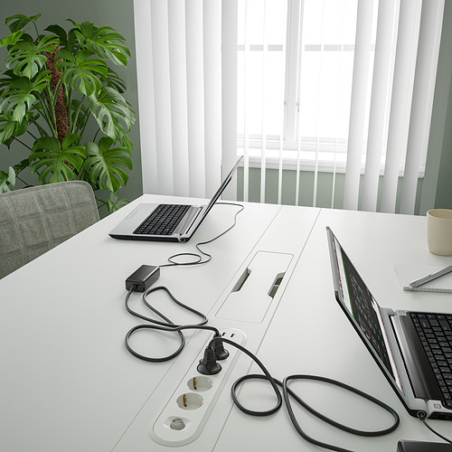 Mesa de conferencias con ordenadores portátiles y regletas de enchufes, con gestión de cables.