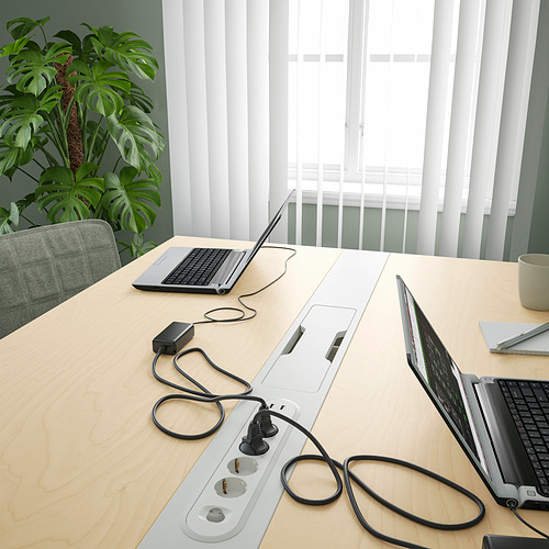 Mesa de oficina con portátiles y cables, ideal para reuniones y trabajo, con gestión de cables.