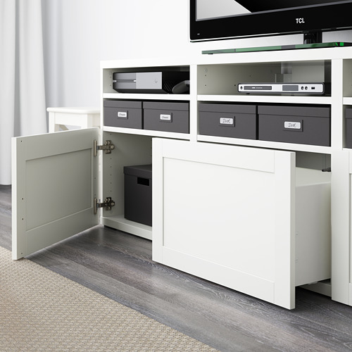 Mueble de TV BESTÅ blanco con puerta abierta, espacio de almacenamiento revelador y estantes ajustables.