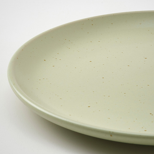 Plato poco profundo, moteado de color verde claro, realizado en gres, que muestra una elegancia rústica.