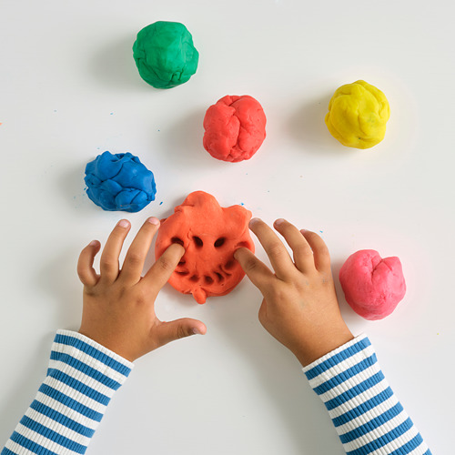 Niños jugando con masa de colores para modelar, fomentando la creatividad y la motricidad fina.