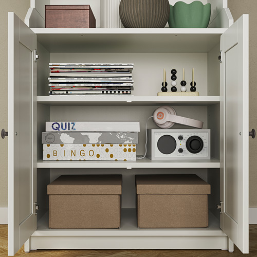 Gabinete blanco con estantes abiertos, exhibiendo juegos, auriculares y cajas de almacenamiento. Muestra almacenamiento oculto y abierto.