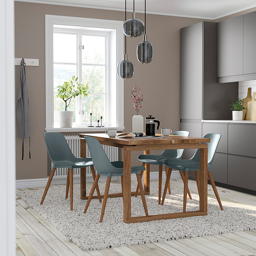 Moderno juego de comedor con sillas GRÖNSTA y una gran ventana, plantas, alfombras y armarios.