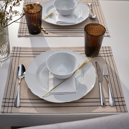 Dos mesas con platos blancos, cubiertos, tazas marrones y manteles individuales beige.