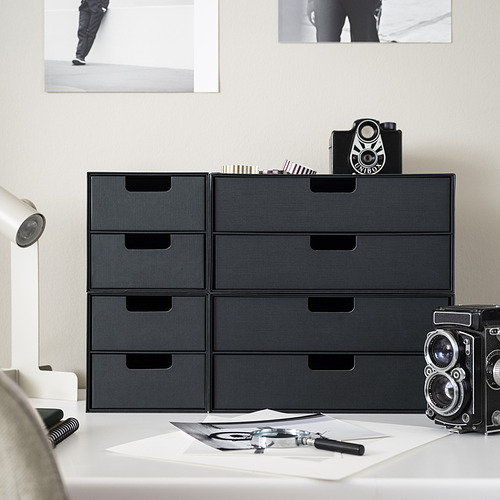 Escritorio moderno organizado con mini baúles negros FJÄDERHARV y cámaras vintage.