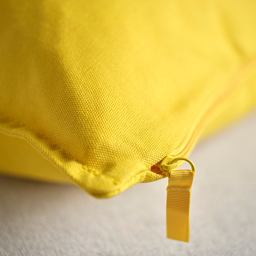 Funda de cojín de color amarillo brillante con cremallera visible y tirador, que muestra costuras y textura de tela de calidad.